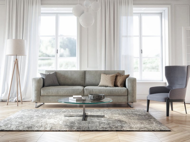 Bright living room with gray couch, hardwood flooring and a large gray area rug from The Family Floor Store in Ellsworth, ME