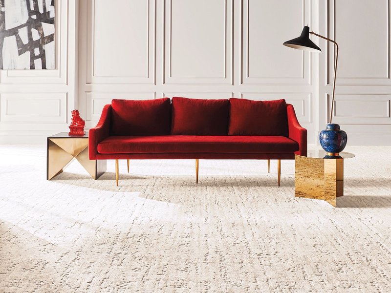 Bright living room with a red velvet couch and beige textured carpet from The Family Floor Store in Ellsworth, ME